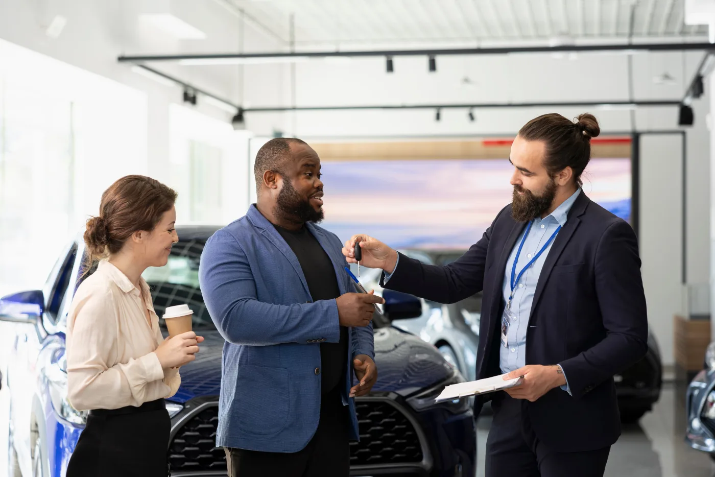 Car buyers receiving their keys from a salesperson